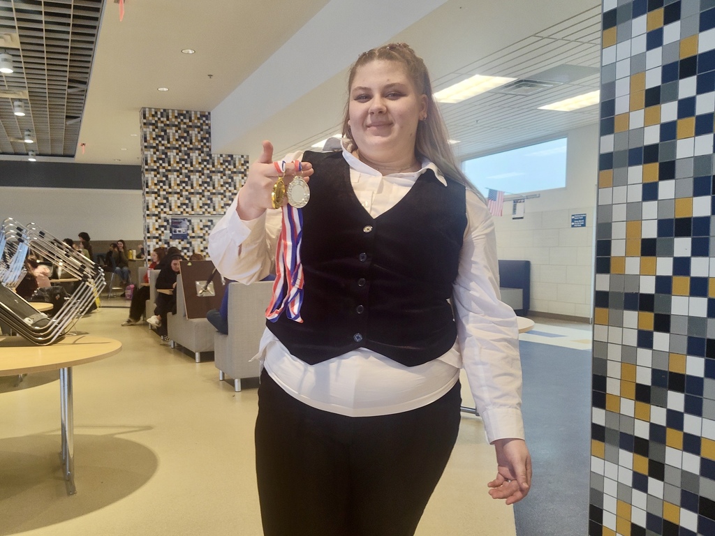 Rain Dorsey smiling holding her awards.