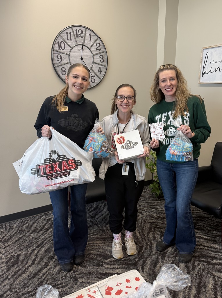 school nurse and texas roadhouse staff holding gifts brought to school