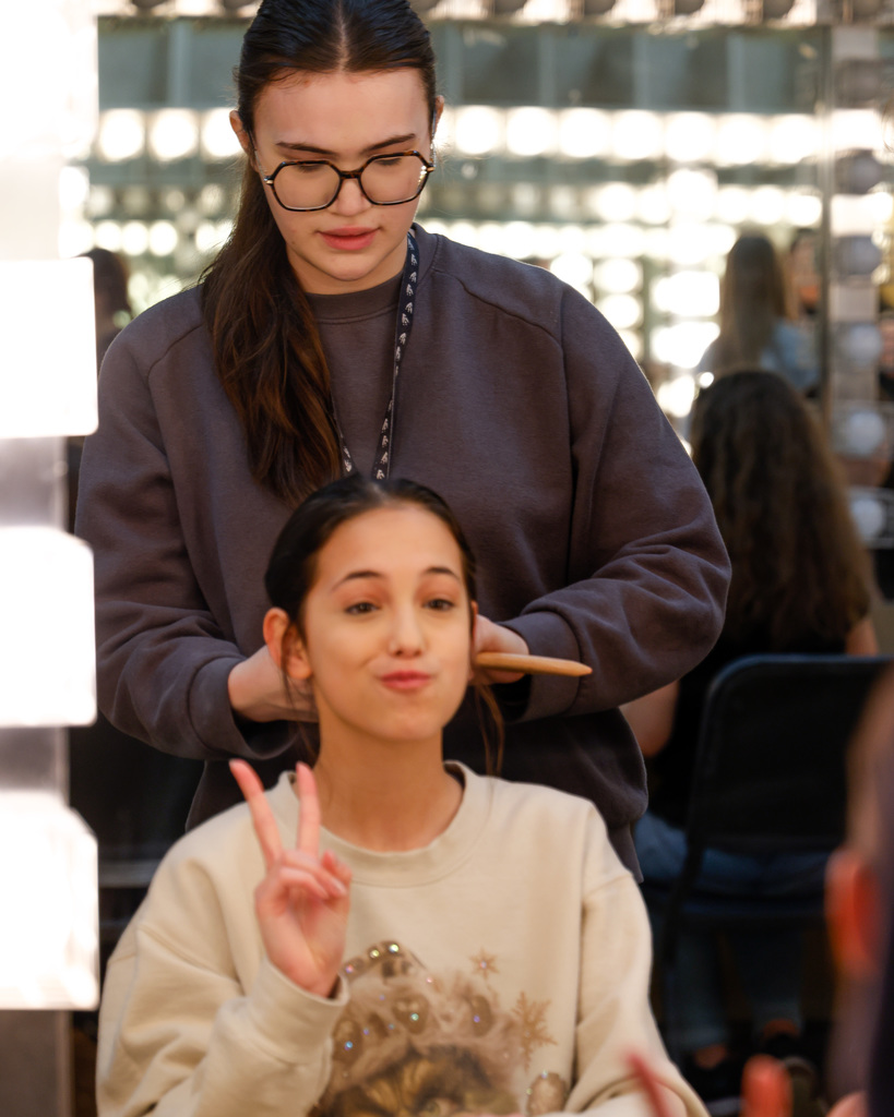 High school student helping Junior high student with make up.
