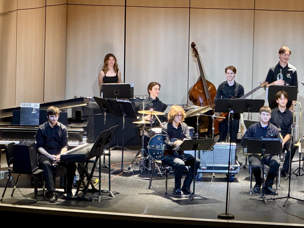 Students smiling on stage during the jazz concert
