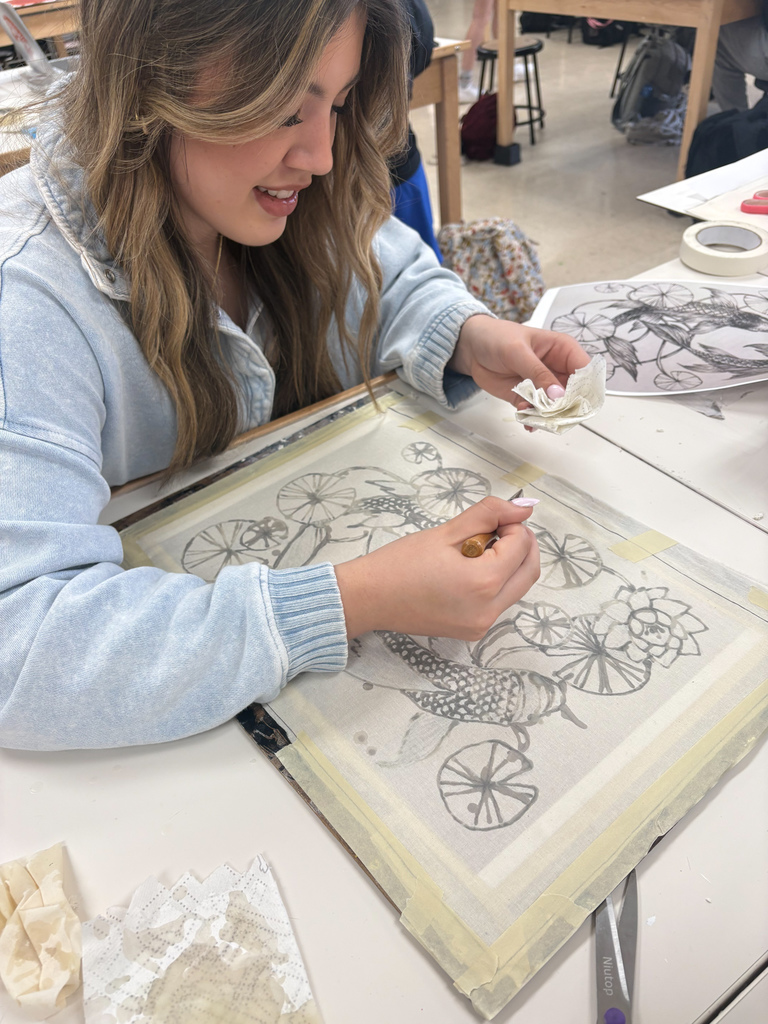 Student working on batik art with birds flowers and Lilypad's 