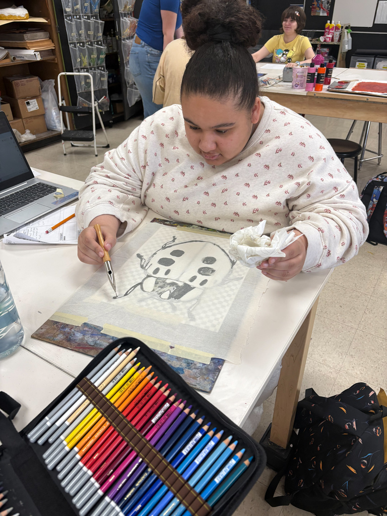Student making a batik art of a large bug