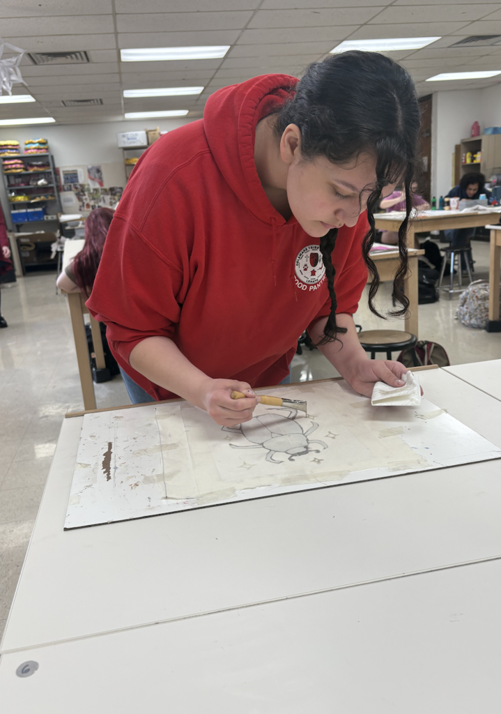 Students are discovering the exciting art of Batik! Batik is a fabric art technique where melted wax is applied to cloth to block out certain areas before dyeing. The wax is drawn on the fabric with a traditional tjanting tool, then the piece is hand painted. To reveal the final masterpiece, students remove the wax by ironing the fabric between sheets of newsprint and then washing away any remaining residue—unveiling bold contrasts, luminous color, and rich designs.