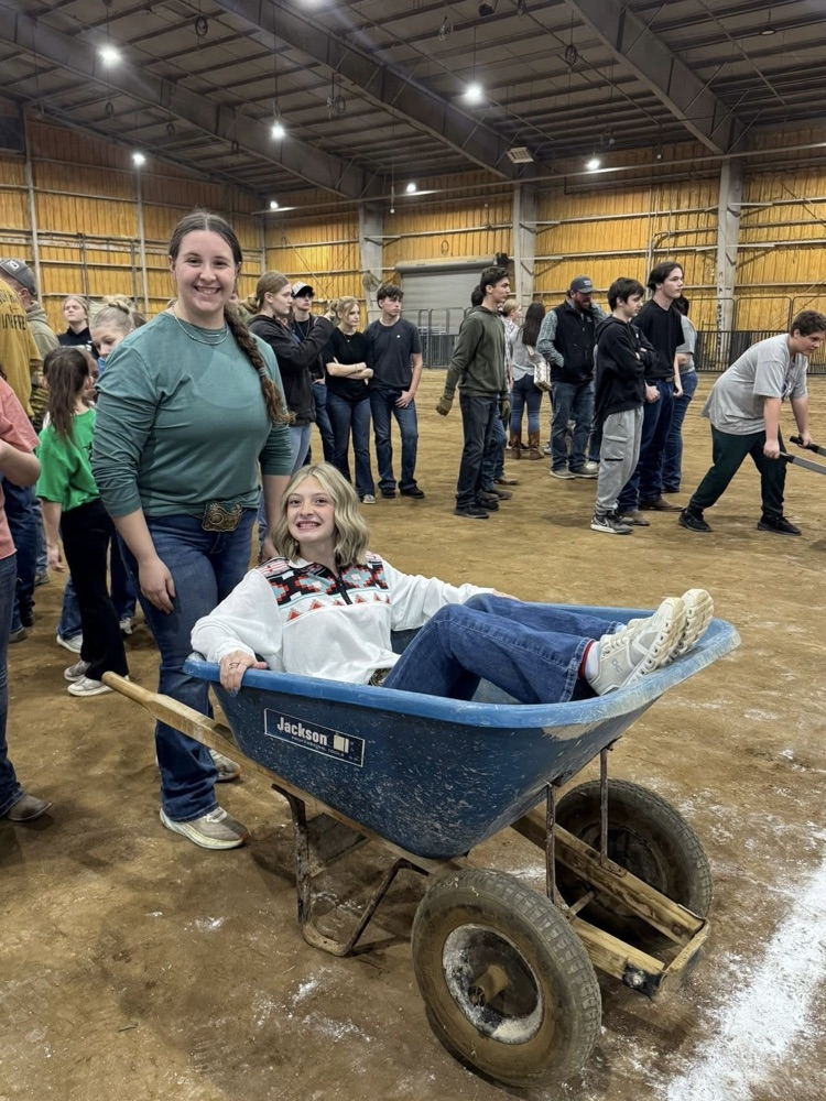 two students with one in a wheelbarrow