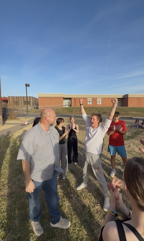 Student celebrating with teacher outside at musical rehearsal 