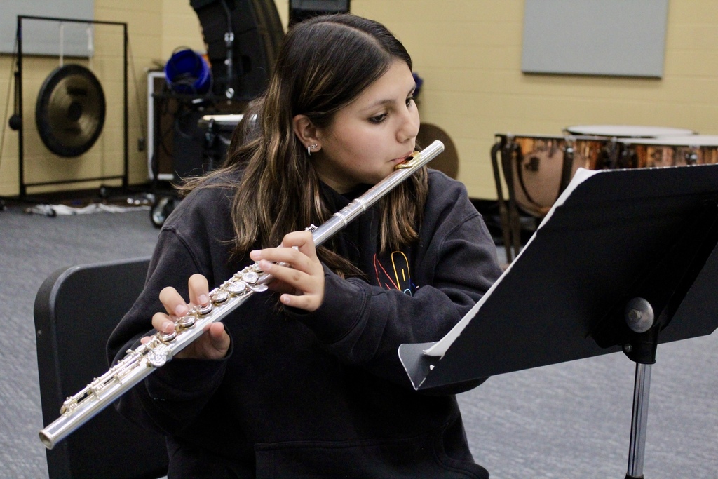 Student playing flute in the band room