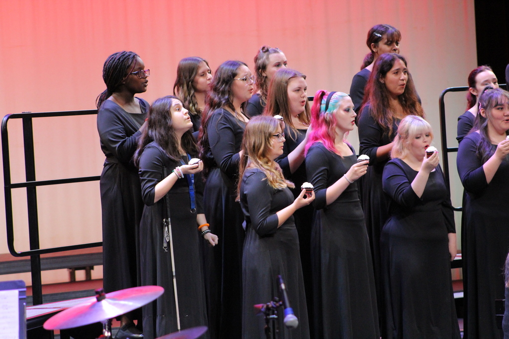 CHS Women's Choir holding red velvet cupcakes singing a song about a red velvet cupcake