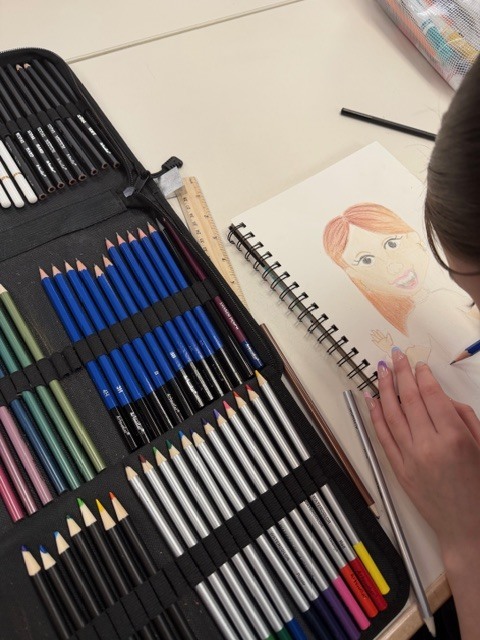 Student using colored pencils to draw a caricature 
