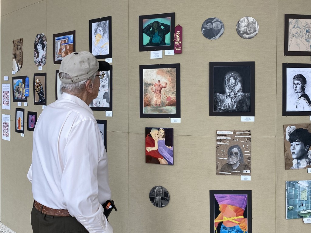 Person looking at art on wall 