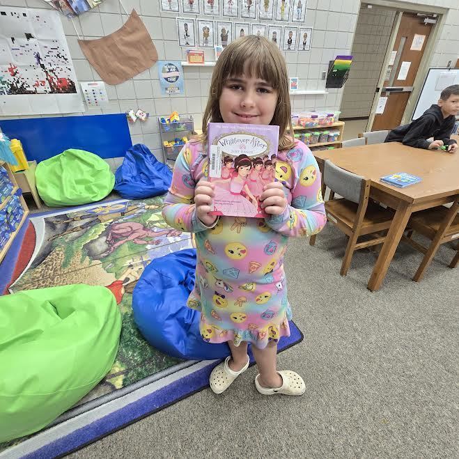 student holding book smiling