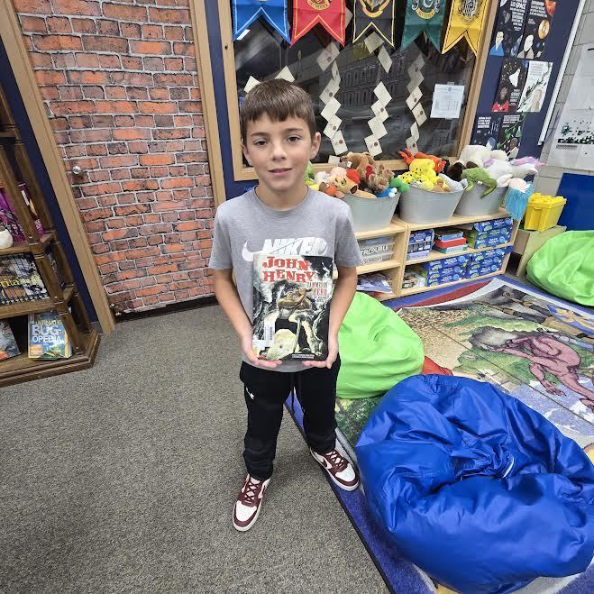 student holding book smiling