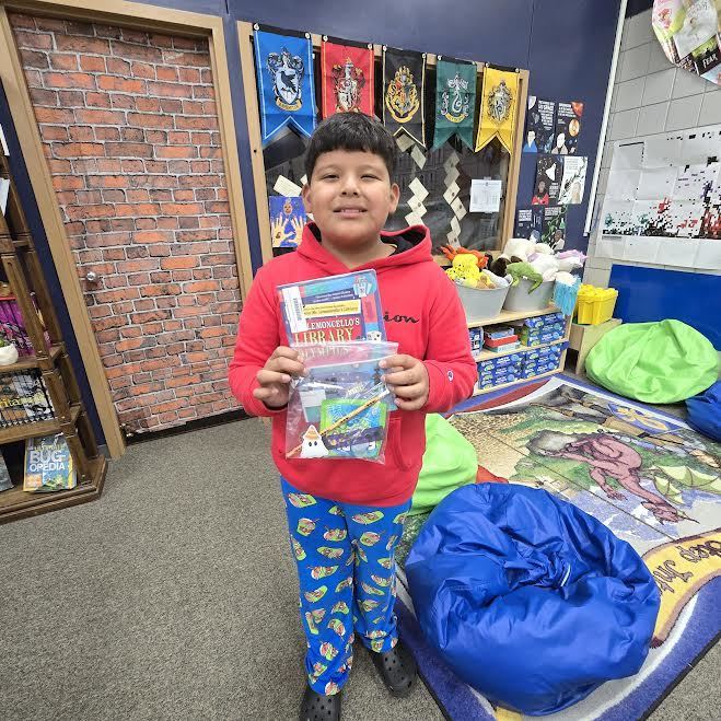 student holding book and prize