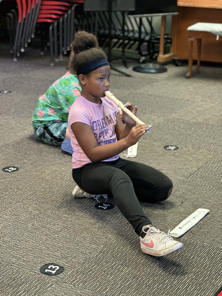 Student playing a recorder in music class.