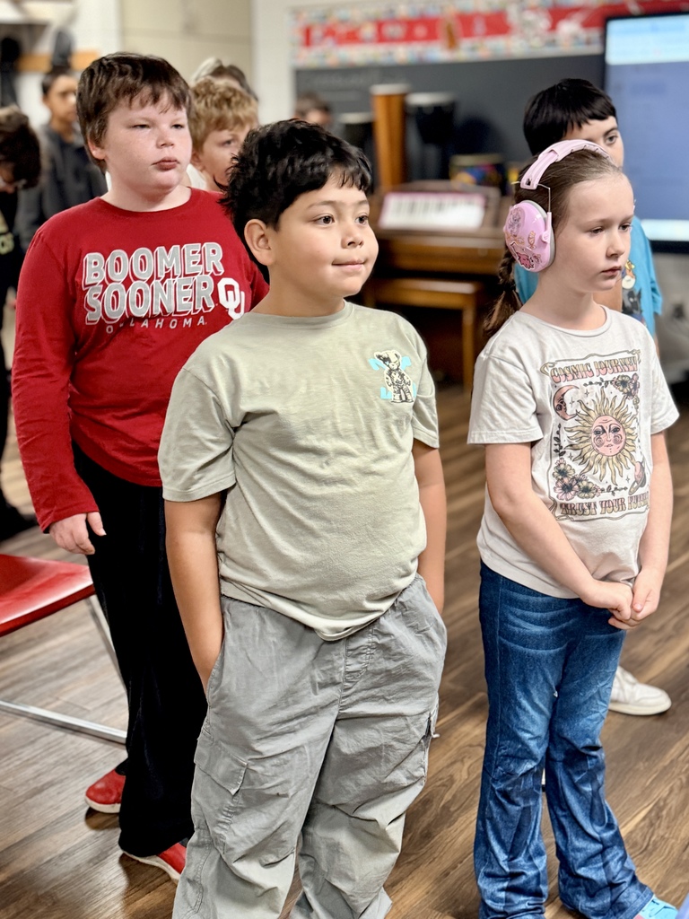 Students listening to their music teacher give instructions in class