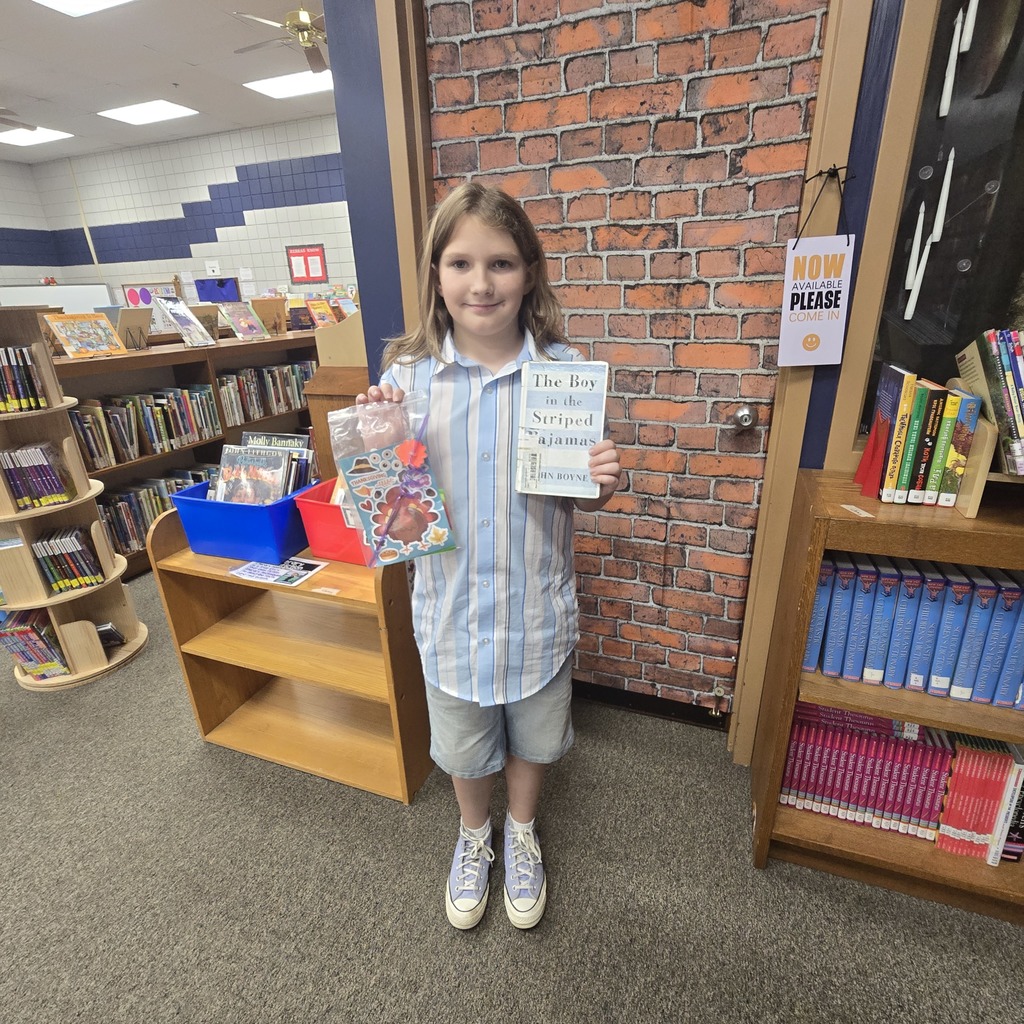 Student holding a book and a prize