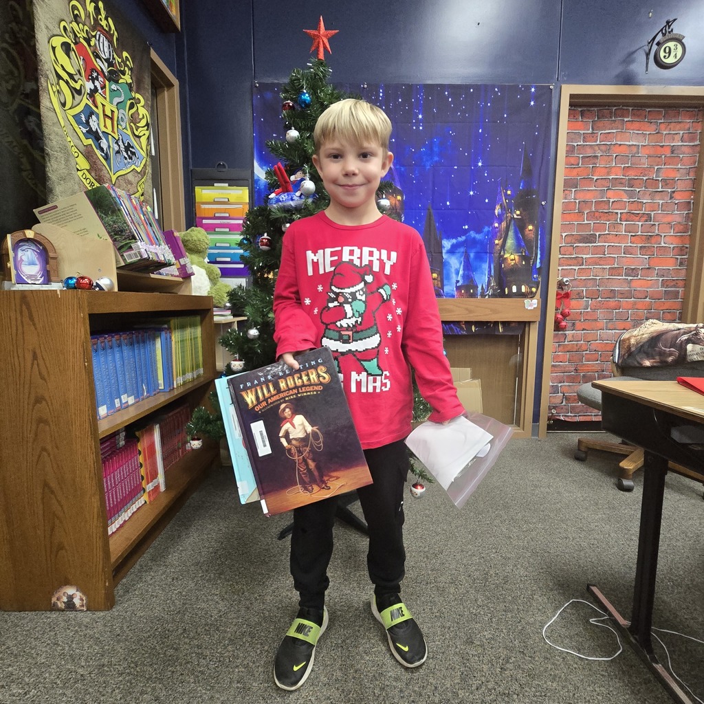 student holding book and prize