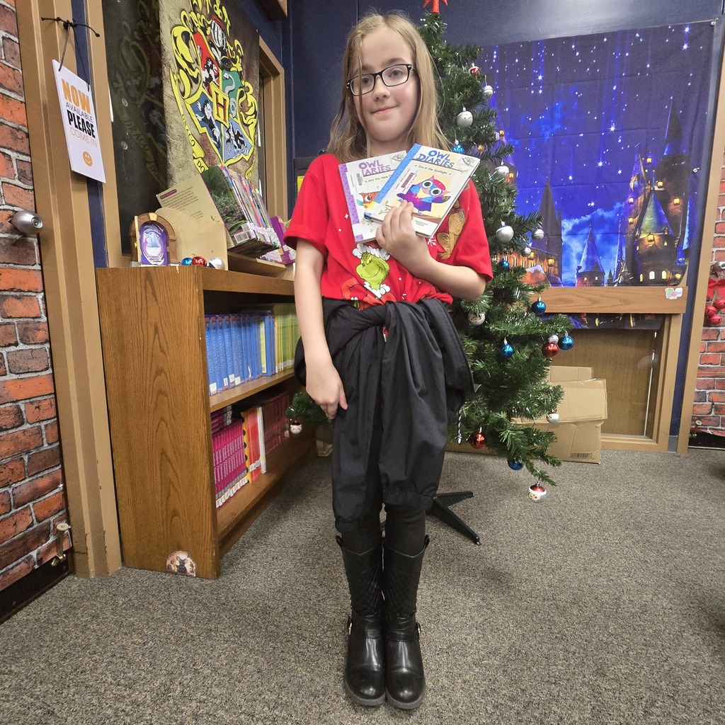 student holding book and prize
