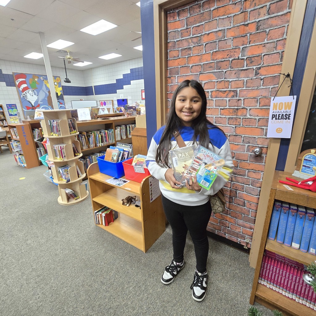 student holding book and prize