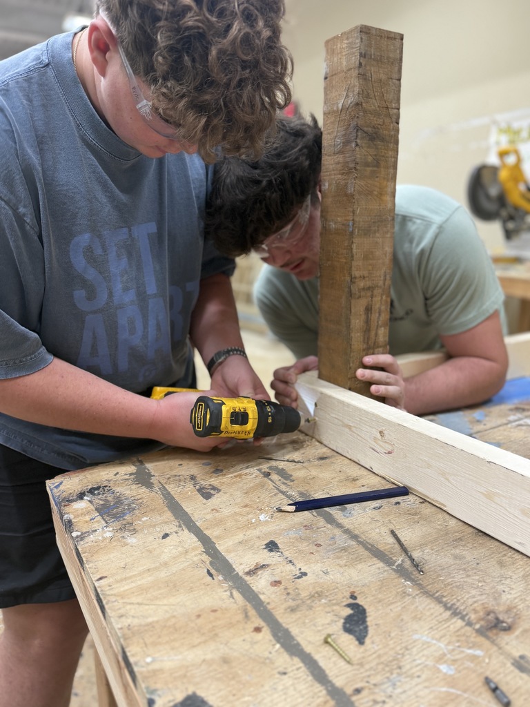 Student using power tool to screw something in 