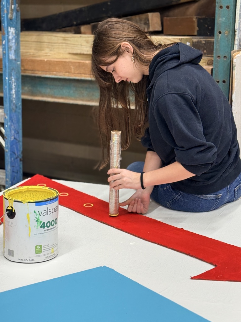 Student painting a set piece