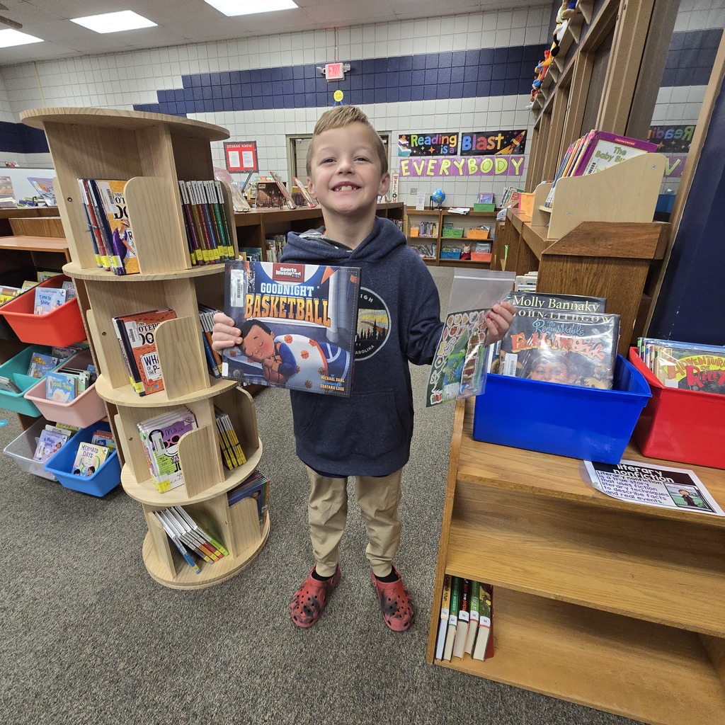 student holding book and prize