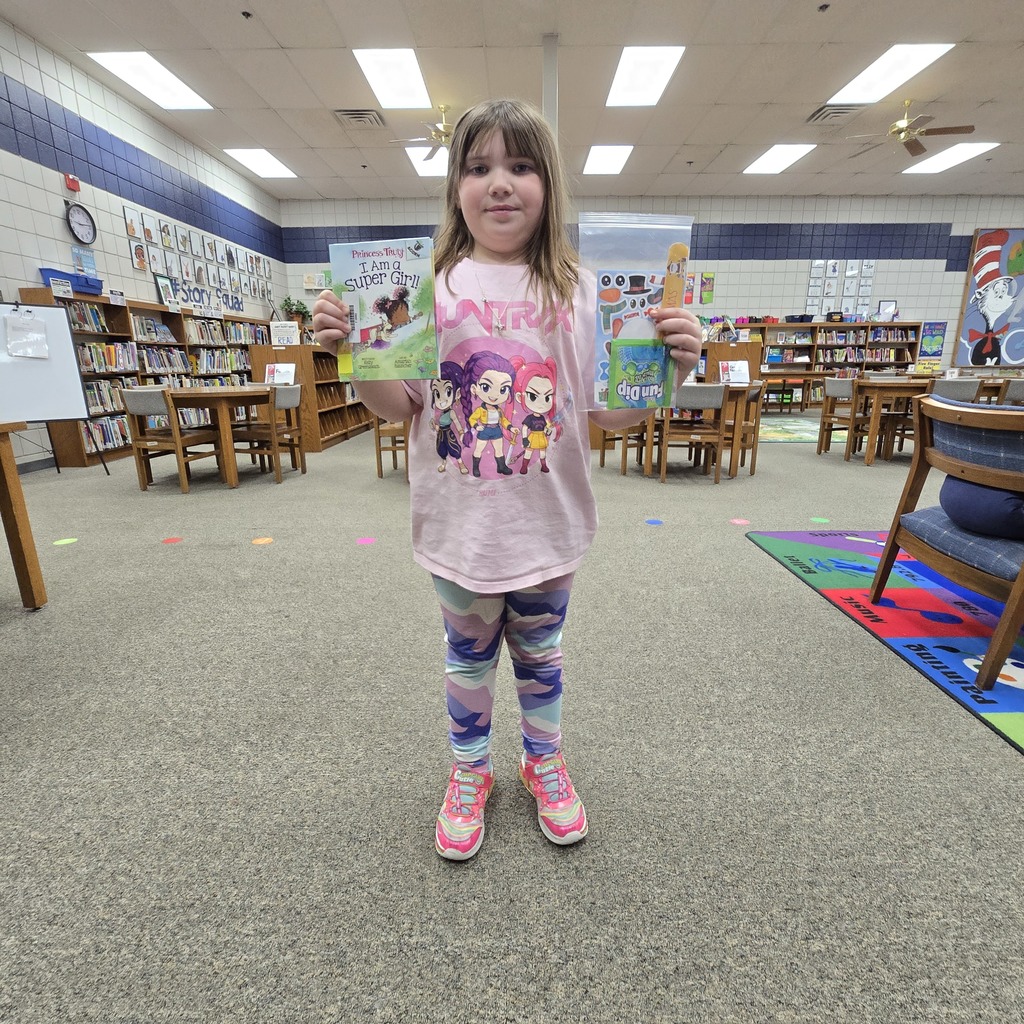 student holding book and prize
