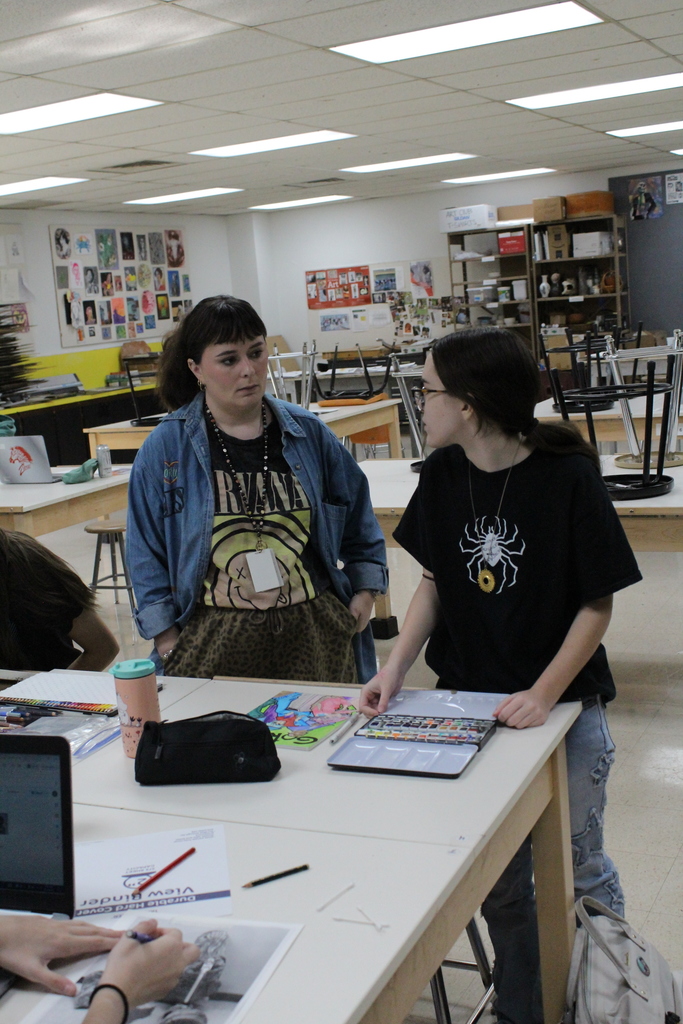 Art teacher working with a student in the class room 