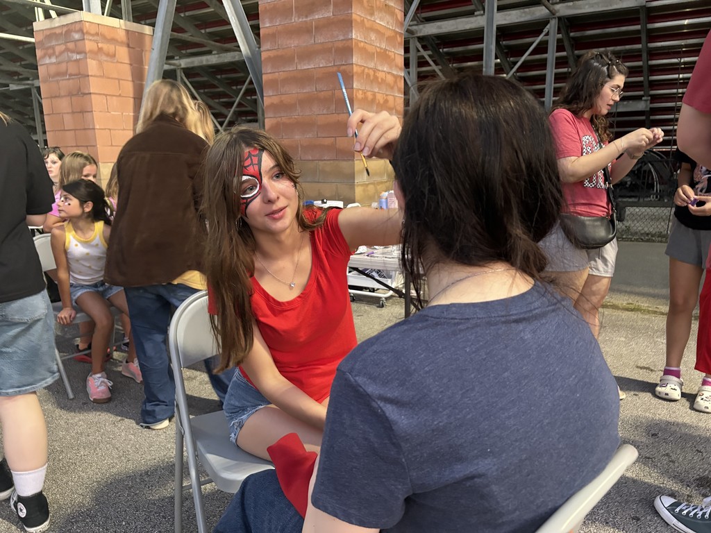 Student painting faces at the football game