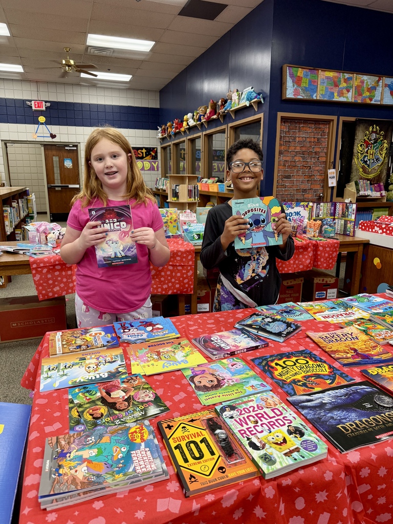 students holding books smiling