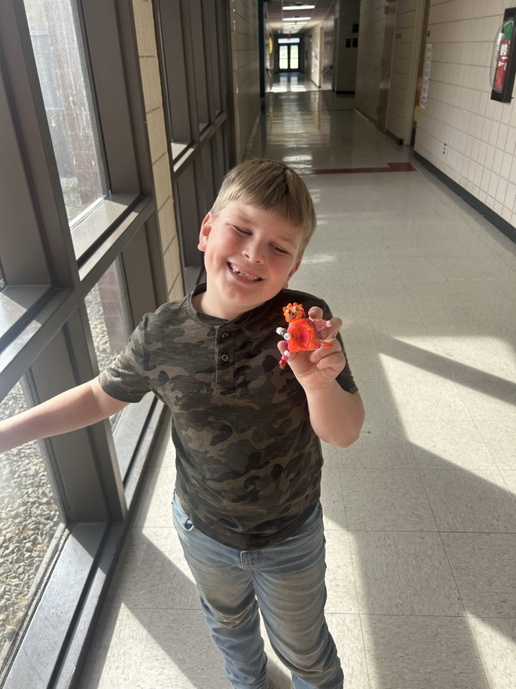 Student holding his completed art project