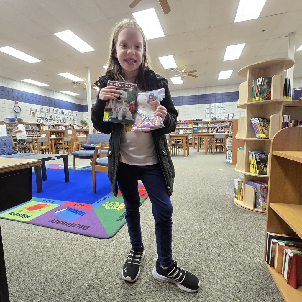 student holding book and prize
