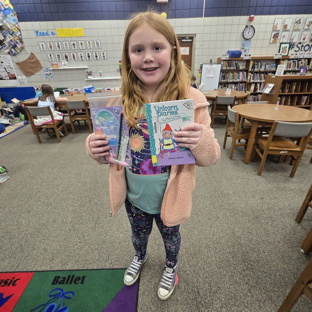 student holding book and prize