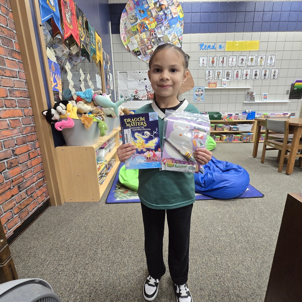 student holding book and prize