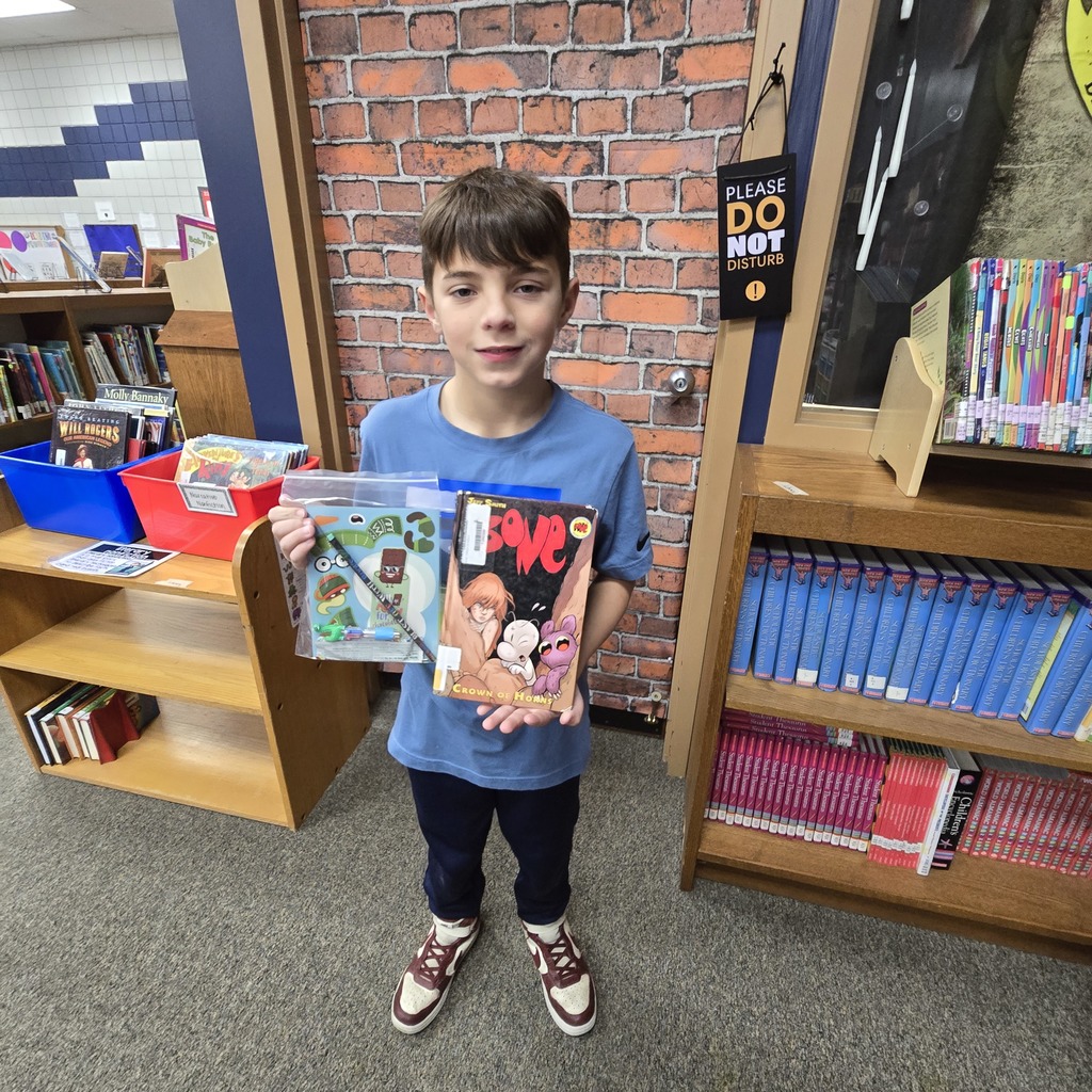 student holding book and prize