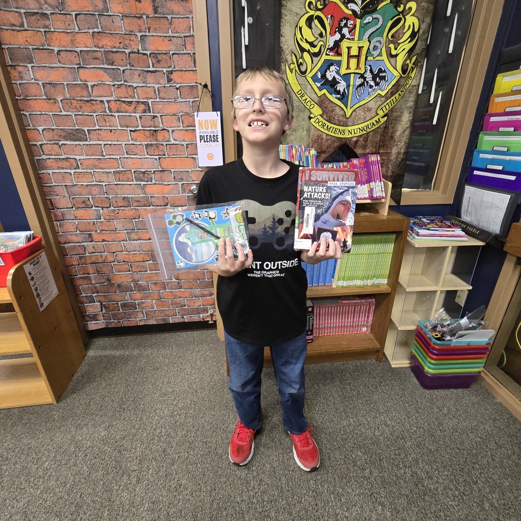 student holding book and prize