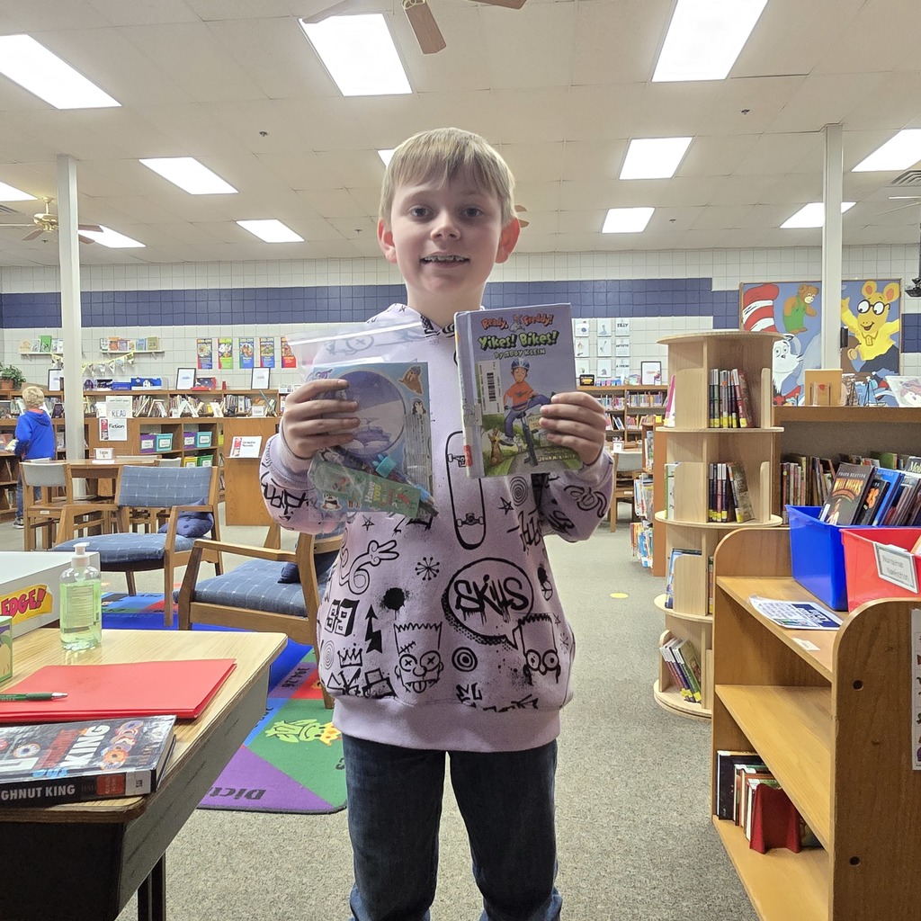 student holding book and prize