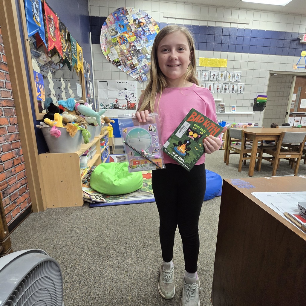 student holding book and prize