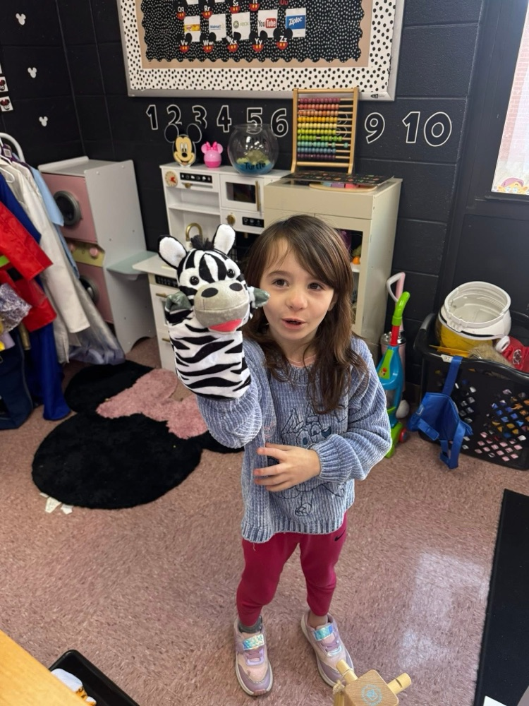 student playing with animal puppet 