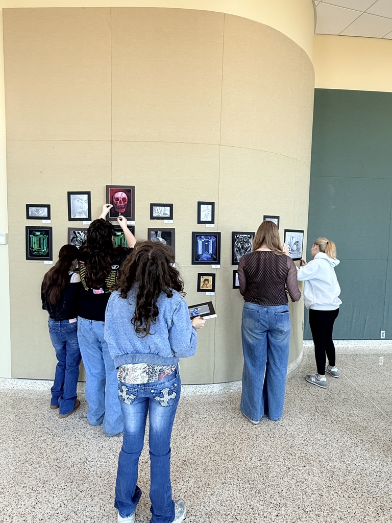 Claremore high school art students hanging up art in the P.A.C.