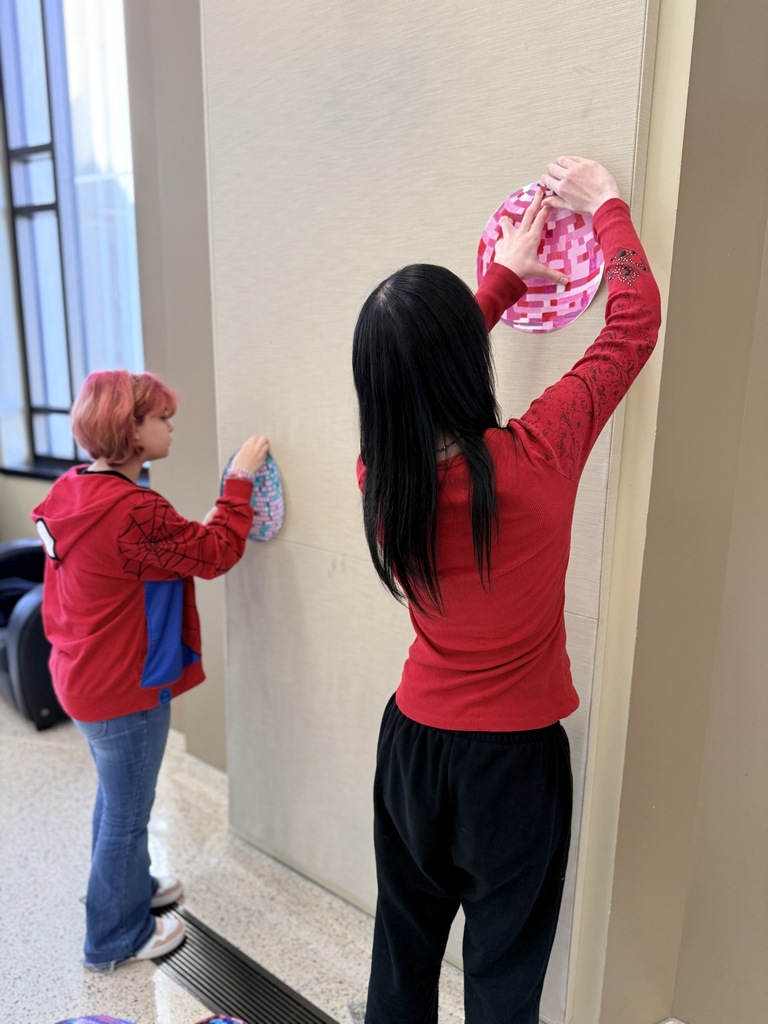 Claremore high school art students hanging up art in the P.A.C.