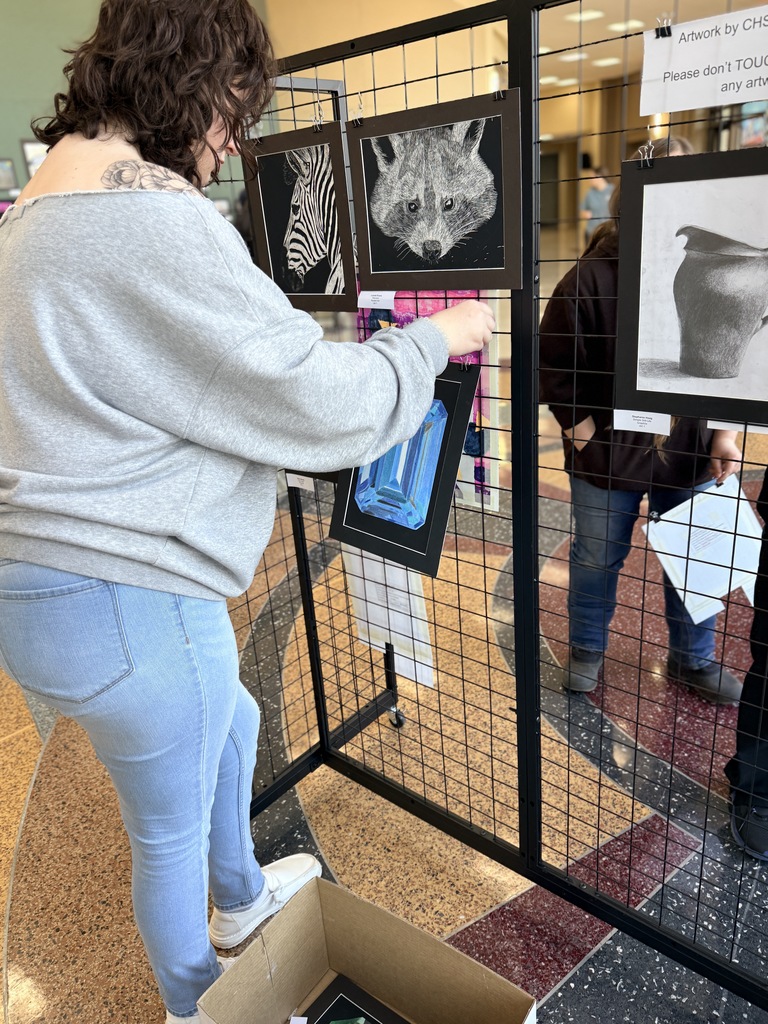 Claremore high school art students hanging up art in the P.A.C.