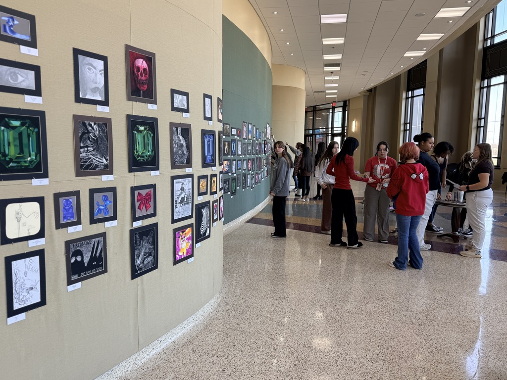 Claremore high school art students hanging up art in the P.A.C.