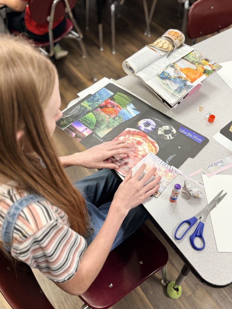 Student cutting pictures out of a magazine to make a collage for art