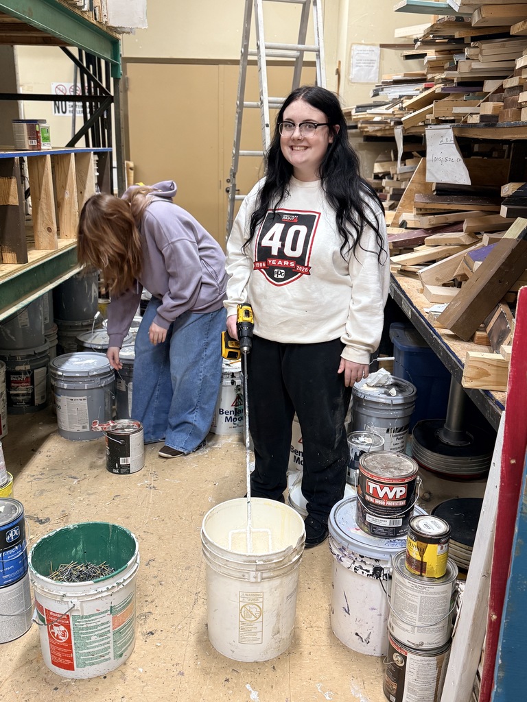 Student mixing paint in the scene shop at the RPAC