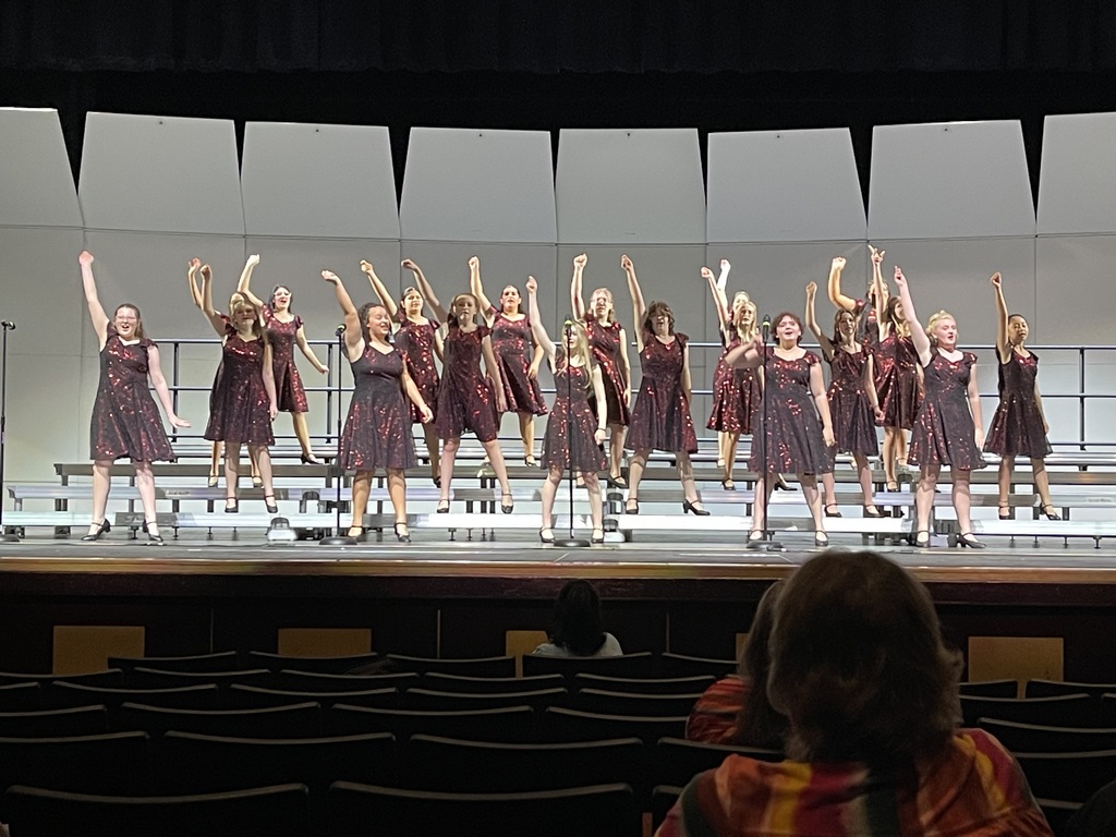 Spark! on stage with their hand in the air singing and dancing