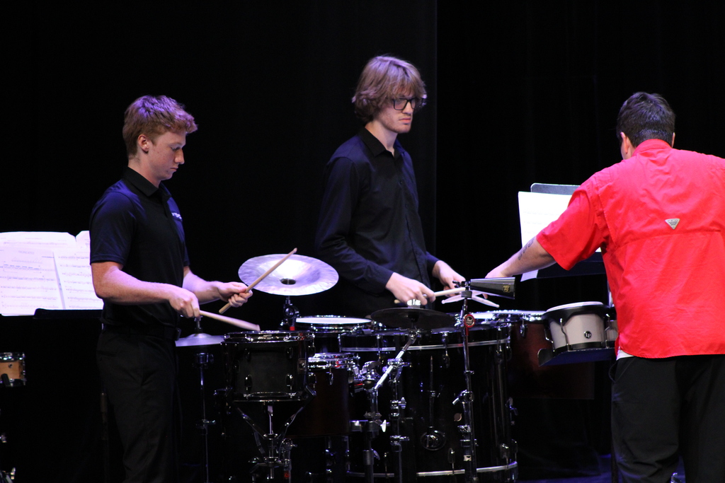 two high school students playing drums in a small ensemble for the concert.