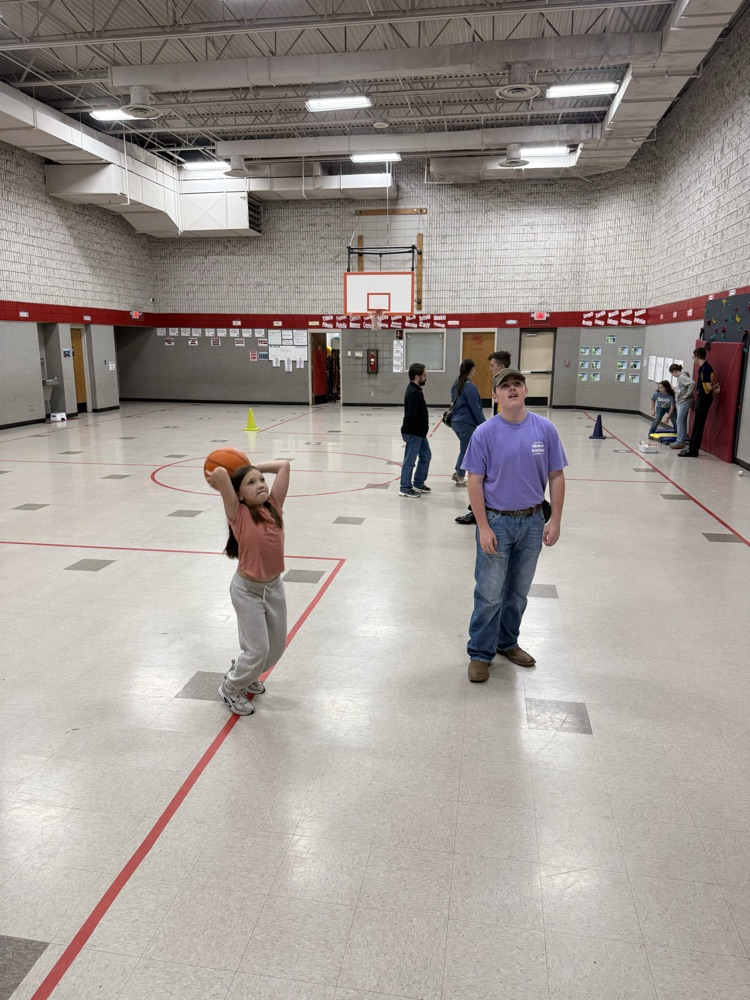 student shooting basketball hoop