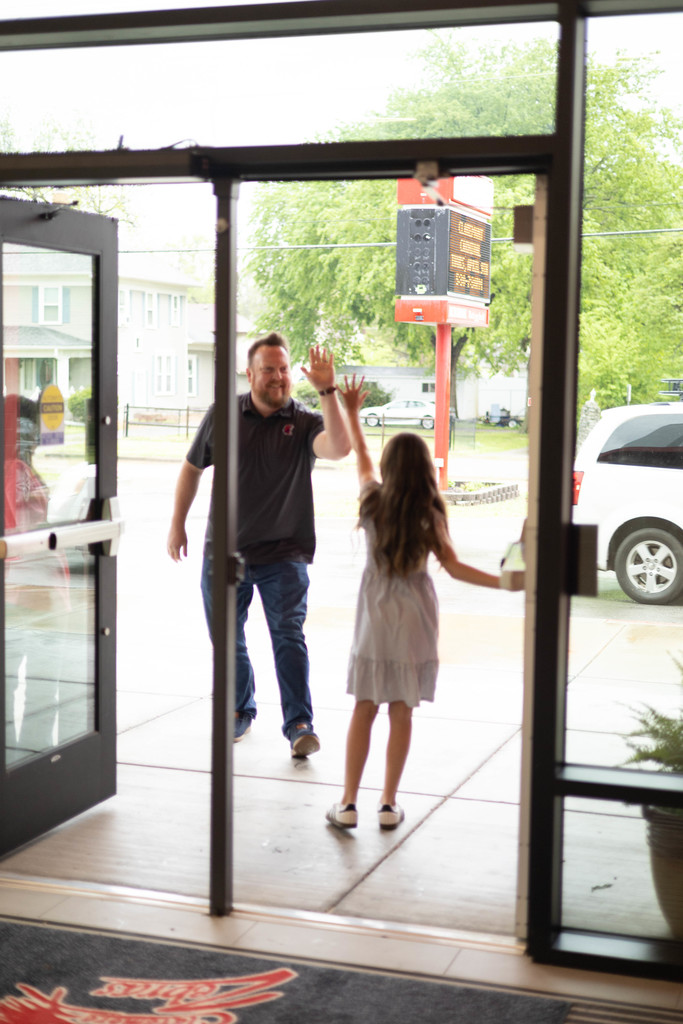 student and visitor giving each other a high five