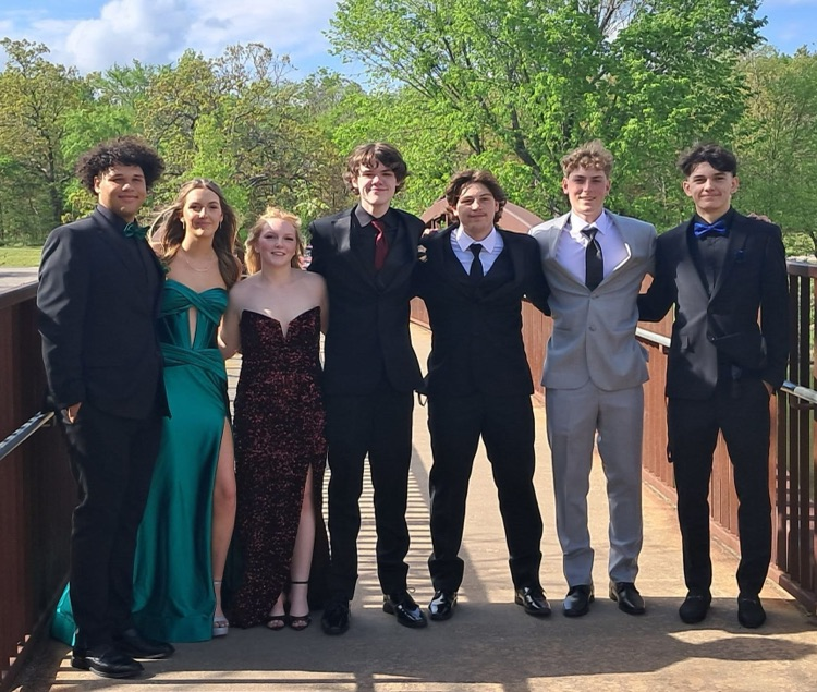 Group of students smiling for picture. Wearing prom attire. 