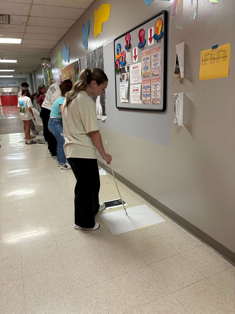 Student in the hall working on her art challenge given by her teacher